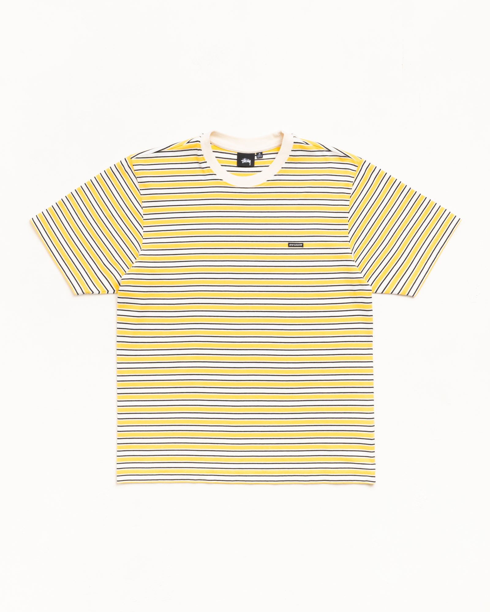 イエロー×ホワイト×ブラックのストライプ柄ユニセックス半袖Tシャツ。ジャージー生地、リブ襟、胸にパッチロゴ。