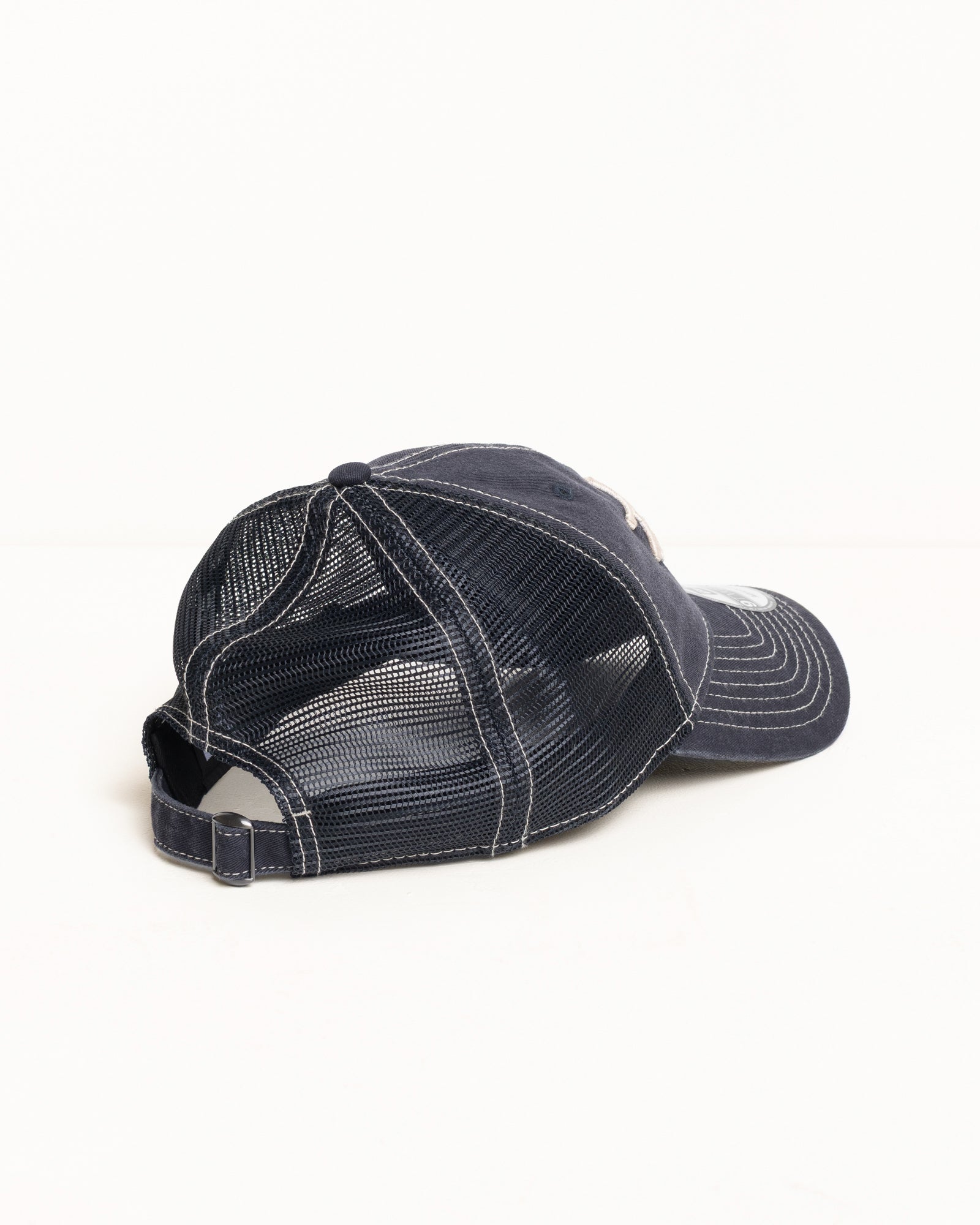 Washed Basic Trucker 9twenty アクセサリー（ネイビーカラー）。Stüssyのロゴ刺繍、ウォッシュ加工されたコットンツイルとメッシュパネル、背面にある金属製留め具付きのストラップバックが特徴のトラッカーキャップ。