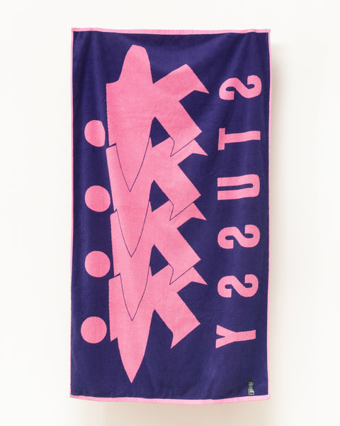 StüssyのSurfman Beach Towel アクセサリー（ピンク）は、コントラストの効いたジャカード織りのサーフマングラフィックが特徴です。