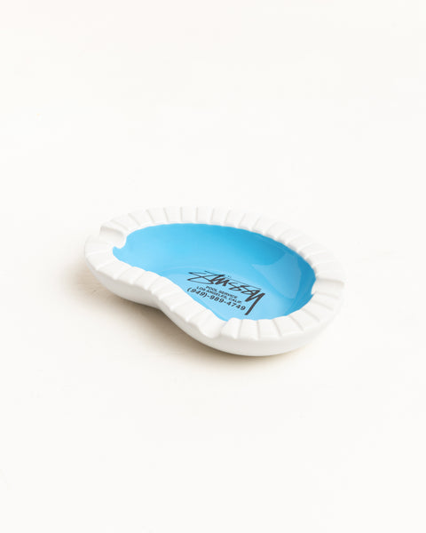 StüssyのPool Service Ashtray Accessories（マルチカラー）は、プールを模したセラミック製で、中央にブランドロゴがプリントされたユニークなデザインのアッシュトレイです。