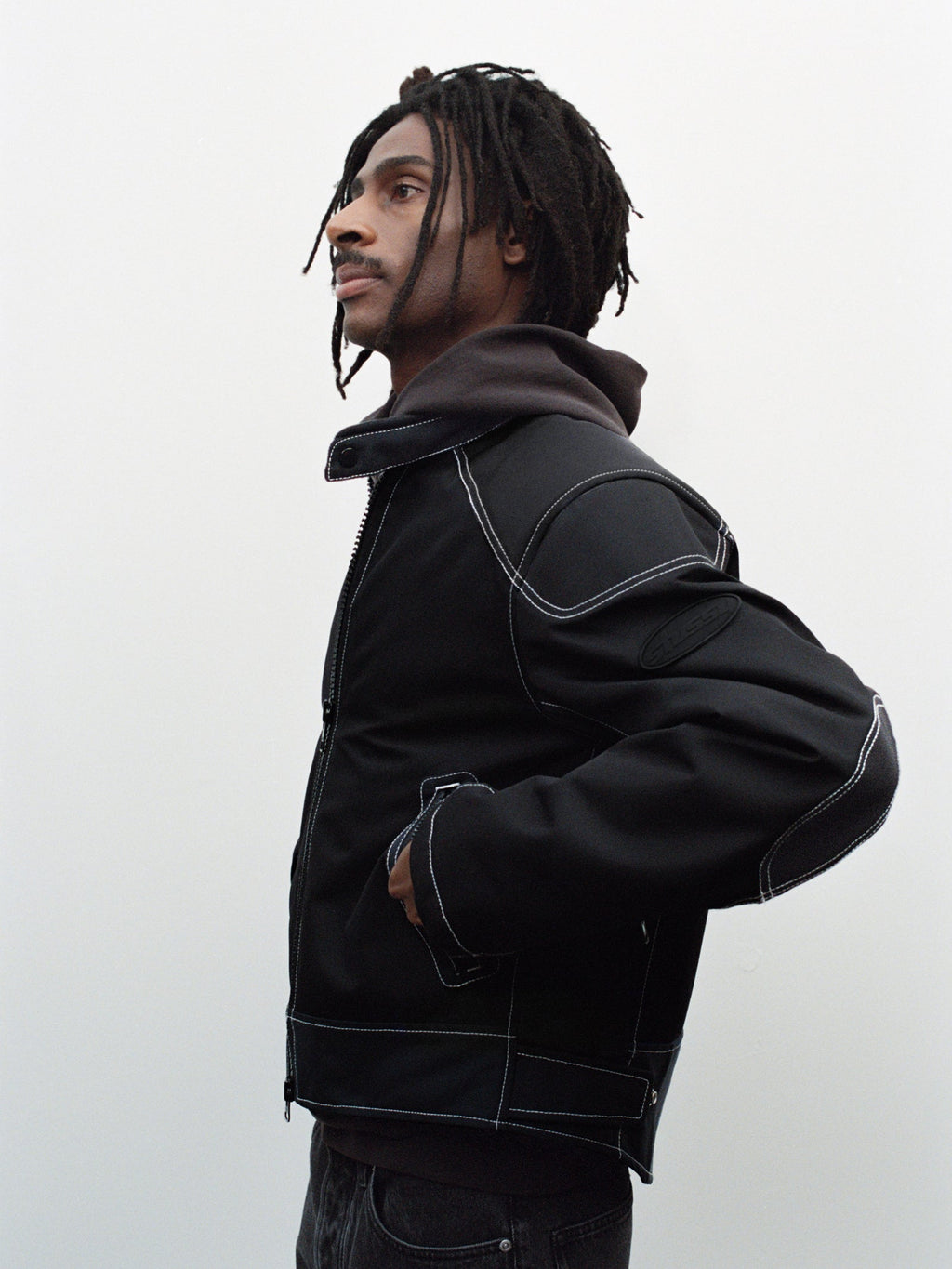 Side-profile of a person wearing the Moto Jacket in Black against a plain background.